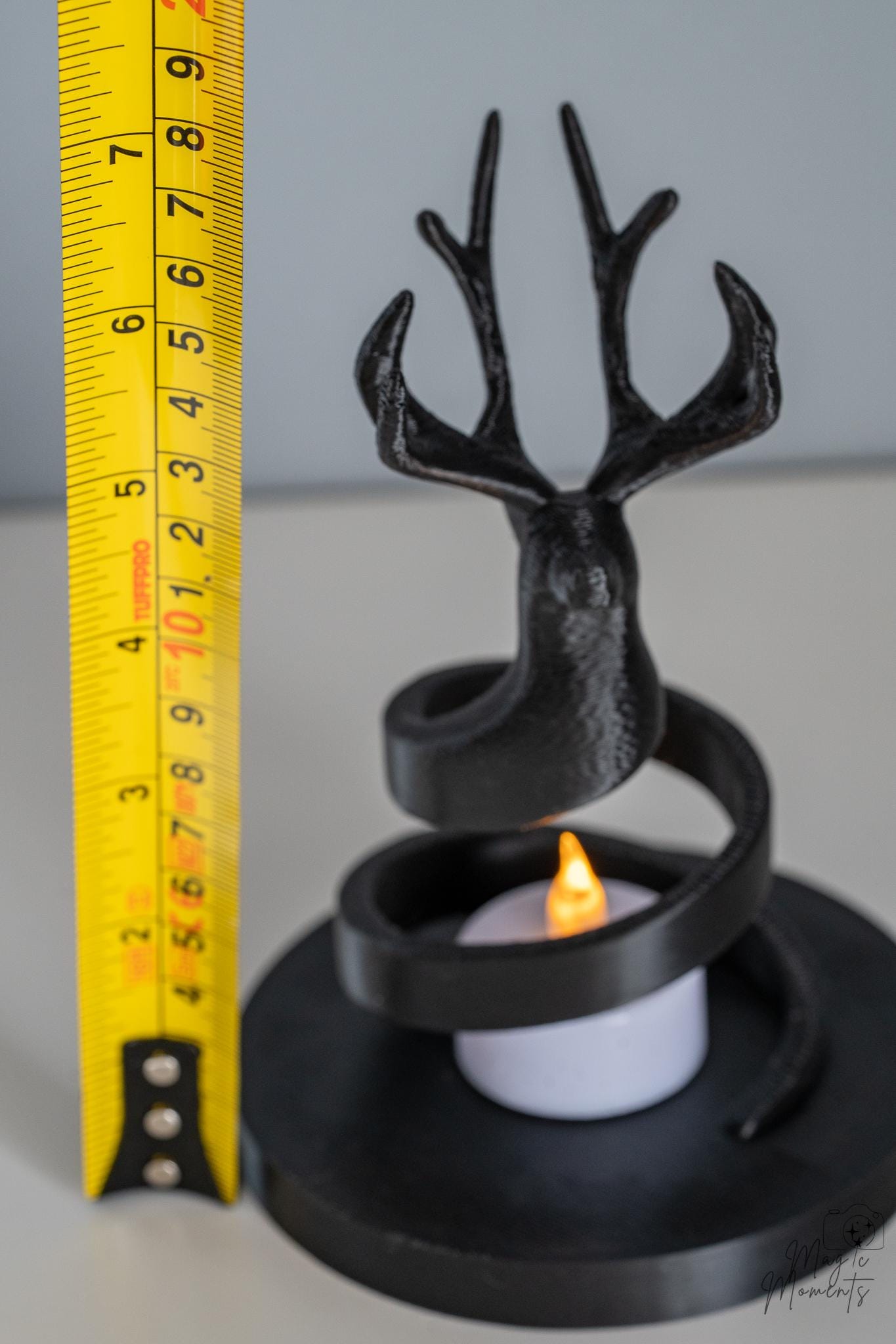 Black deer candle holder next to measuring tape for scale