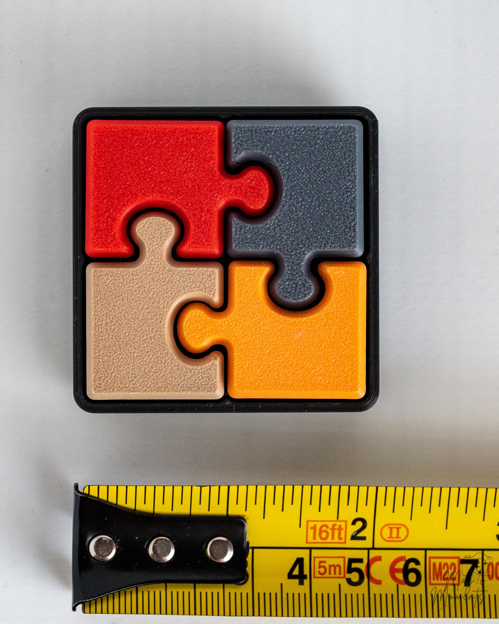puzzle clicker next to measuring tape for scale