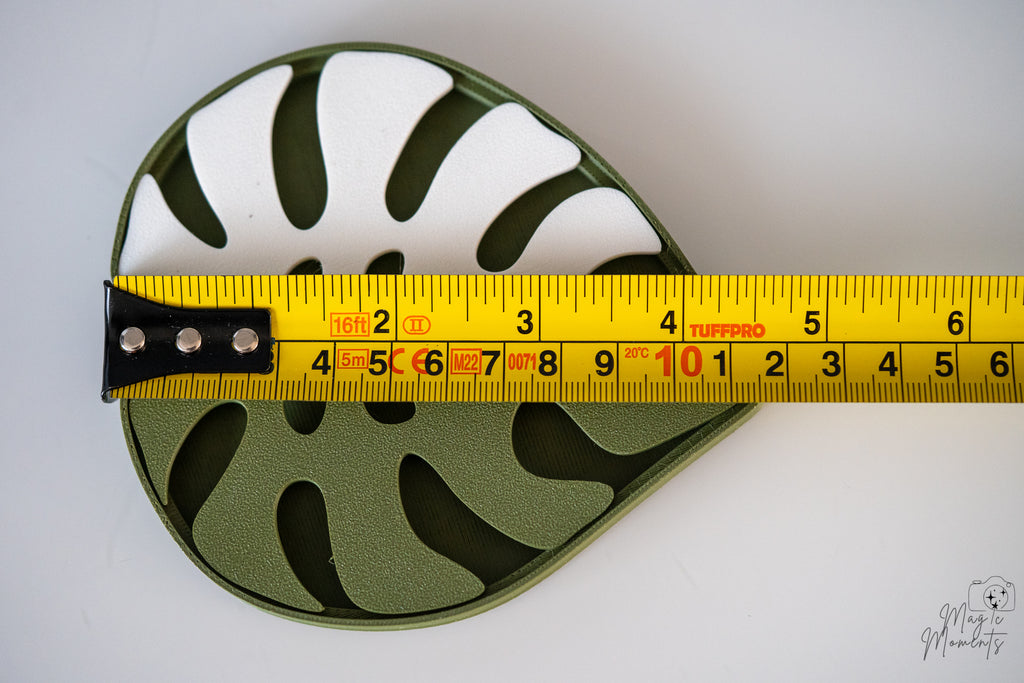 Monstera leaf soap dish next to measuring tape for scale