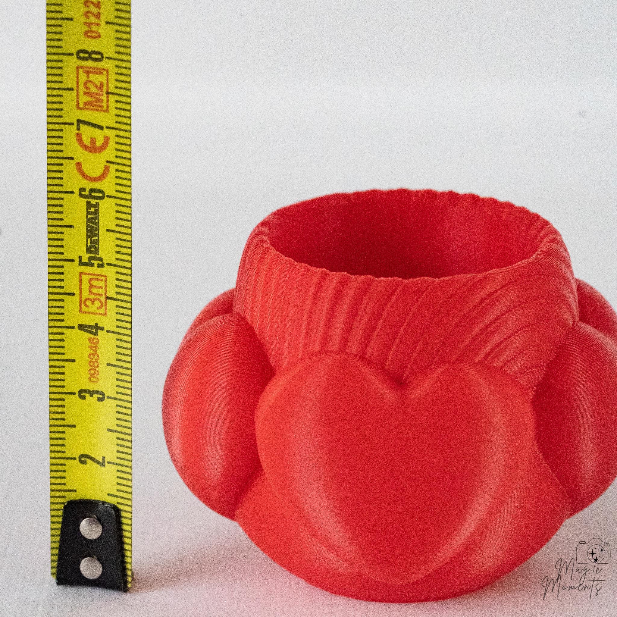 Red heart tealight holder next to measuring tape for scale