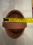 brown woven basket side view next to measuring tape for scale