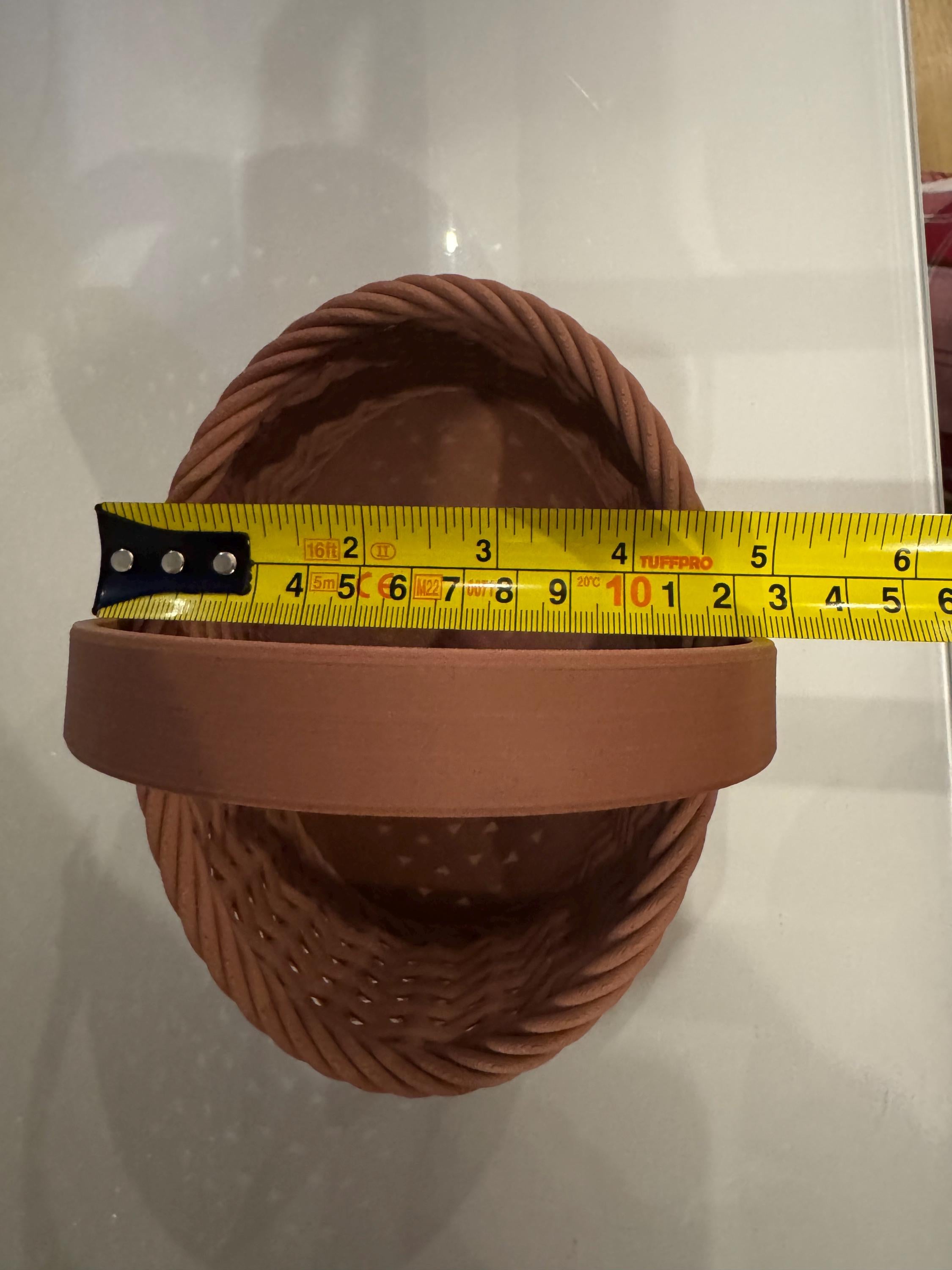 brown woven basket side view next to measuring tape for scale
