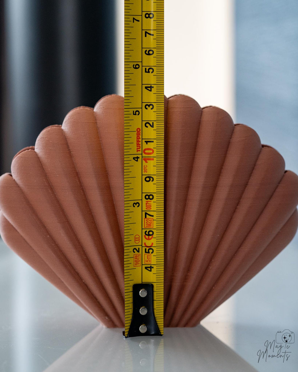 brown shell napkin holder next to measuring tape for scale