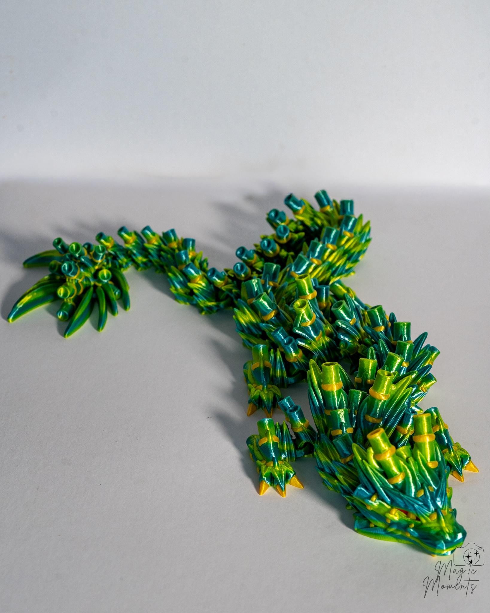 Articulated bamboo dragon figure with green and yellow fantasy design