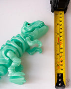 trex dinosaur next to measuring tape for scale