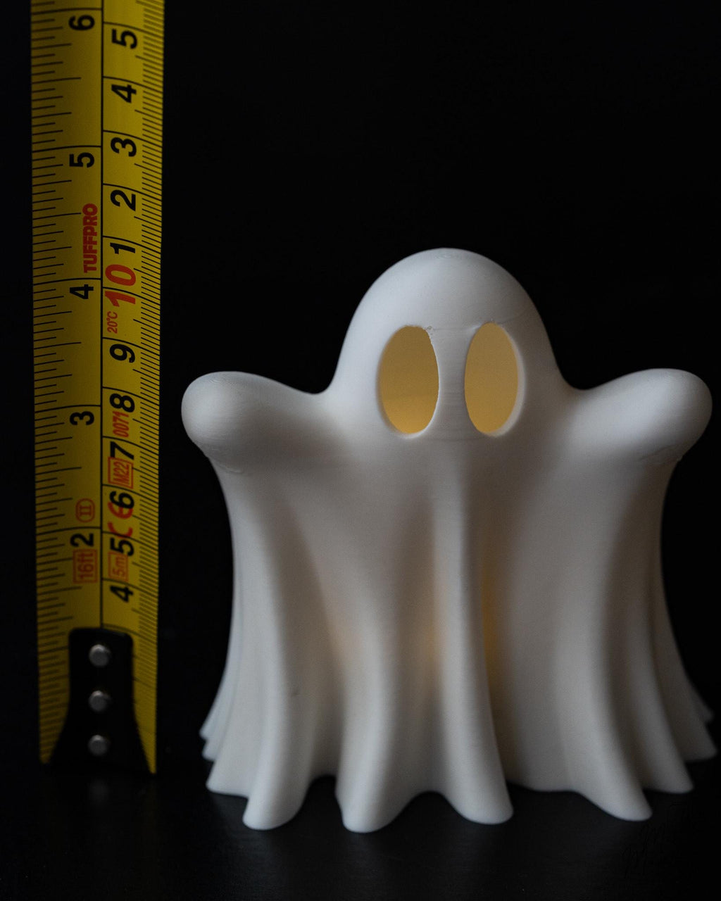 Halloween ghost decor next to measuring tape for scale
