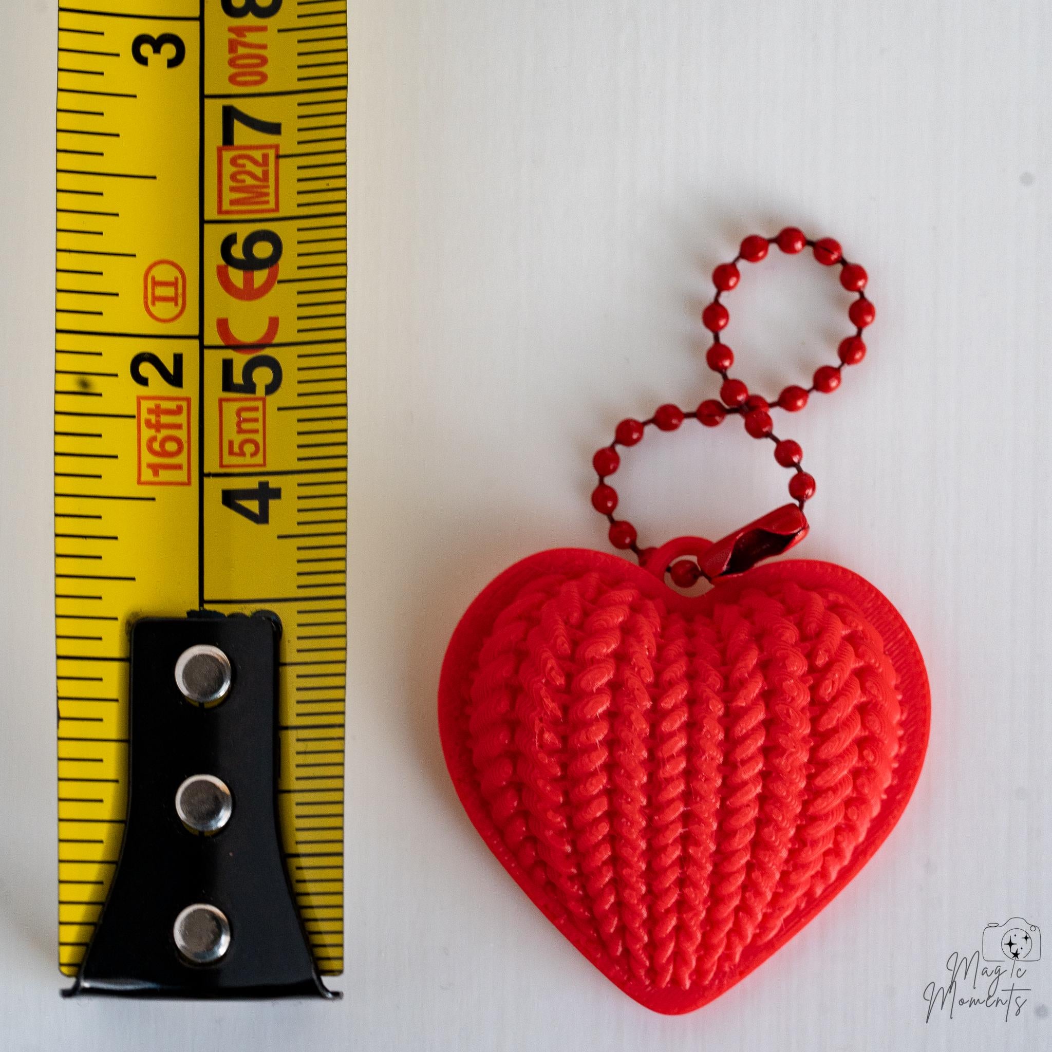 Heart keychain next to measuring tape for scale
