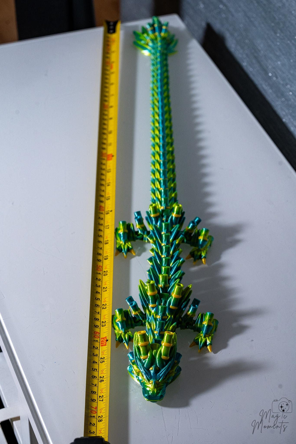 Long articulated bamboo dragon next to measuring tape for scale