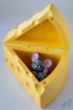 Yellow cheese-shaped container with a small gray mouse figurine