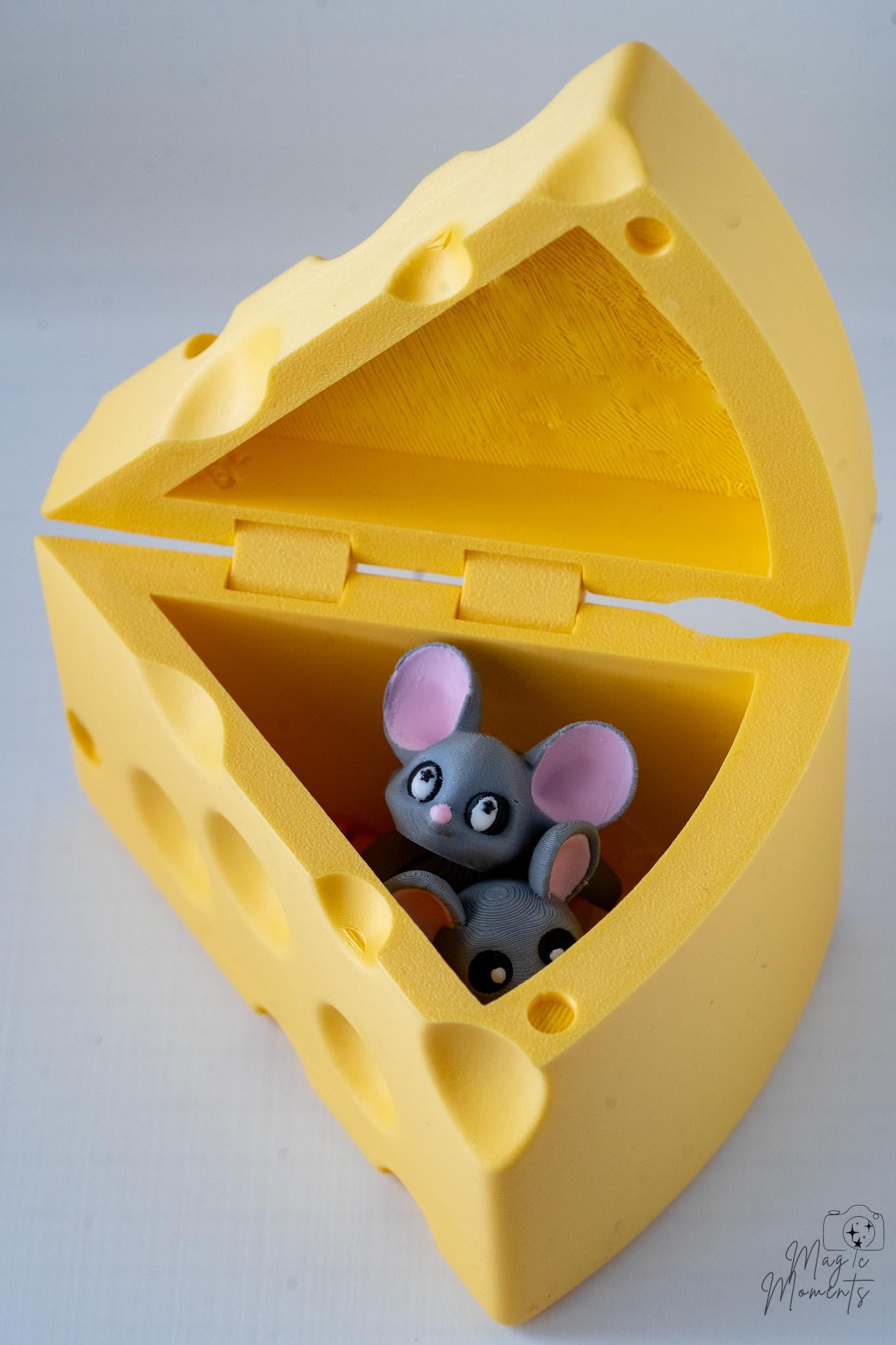 Yellow cheese-shaped container with a small gray mouse figurine