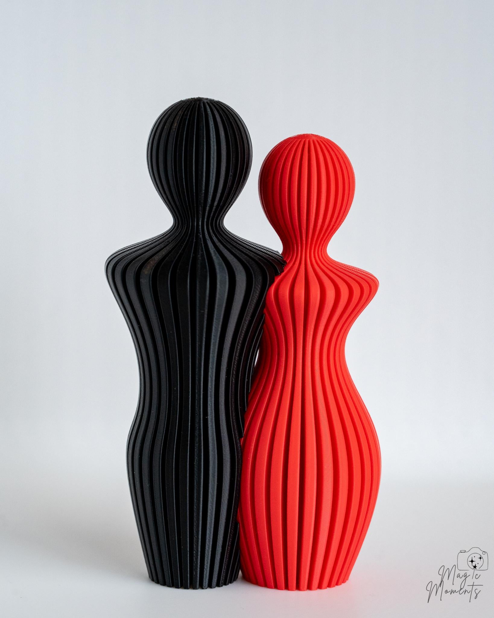 Red and black couple sculpture pair with minimalist ribbed texture