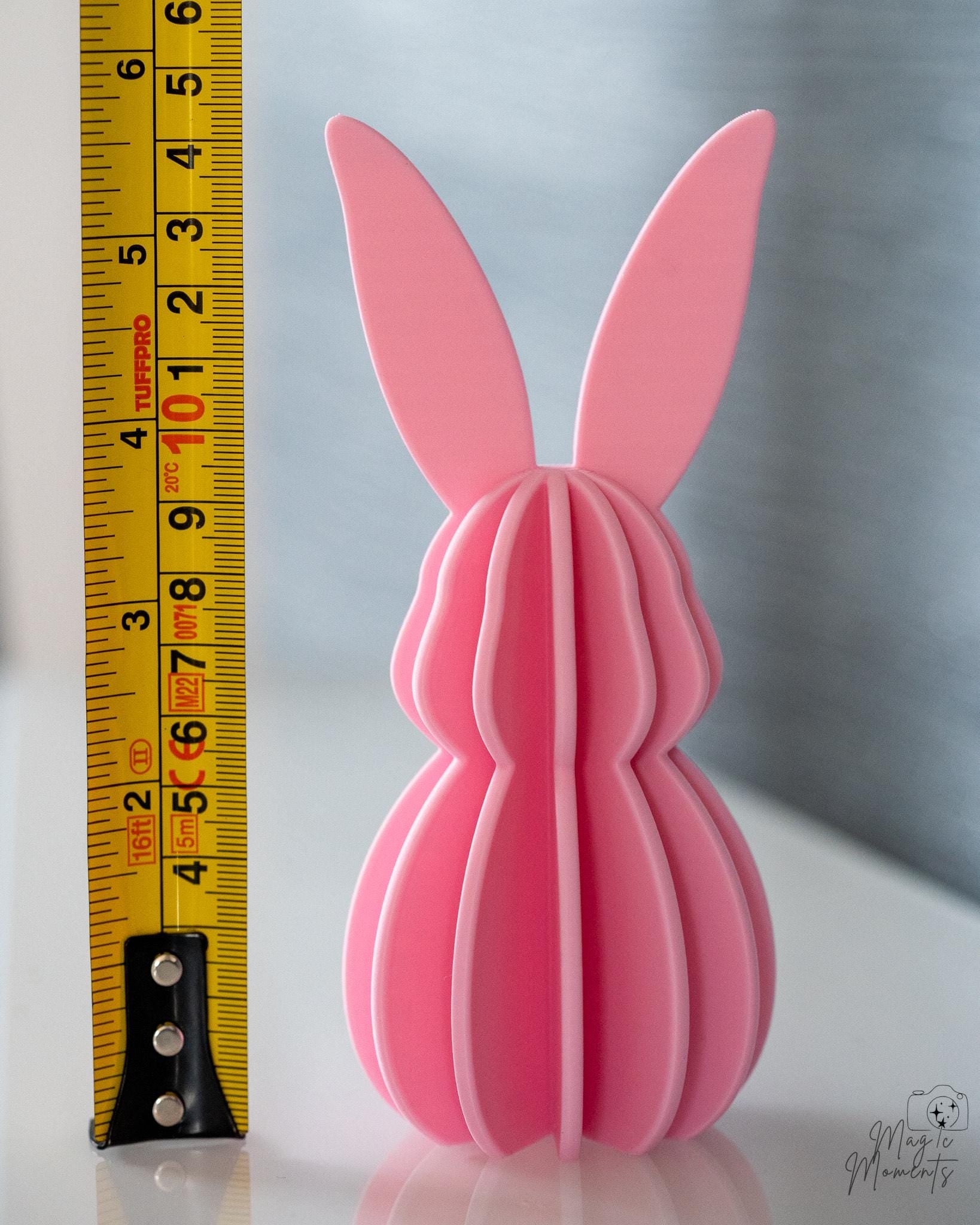 Pink bunny-shaped object next to a ruler for scale