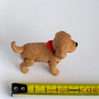 cockapoo figurine next to measuring tape for scale