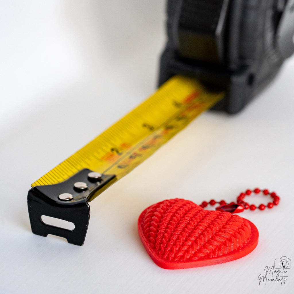 Heart keychain next to measuring tape for scale