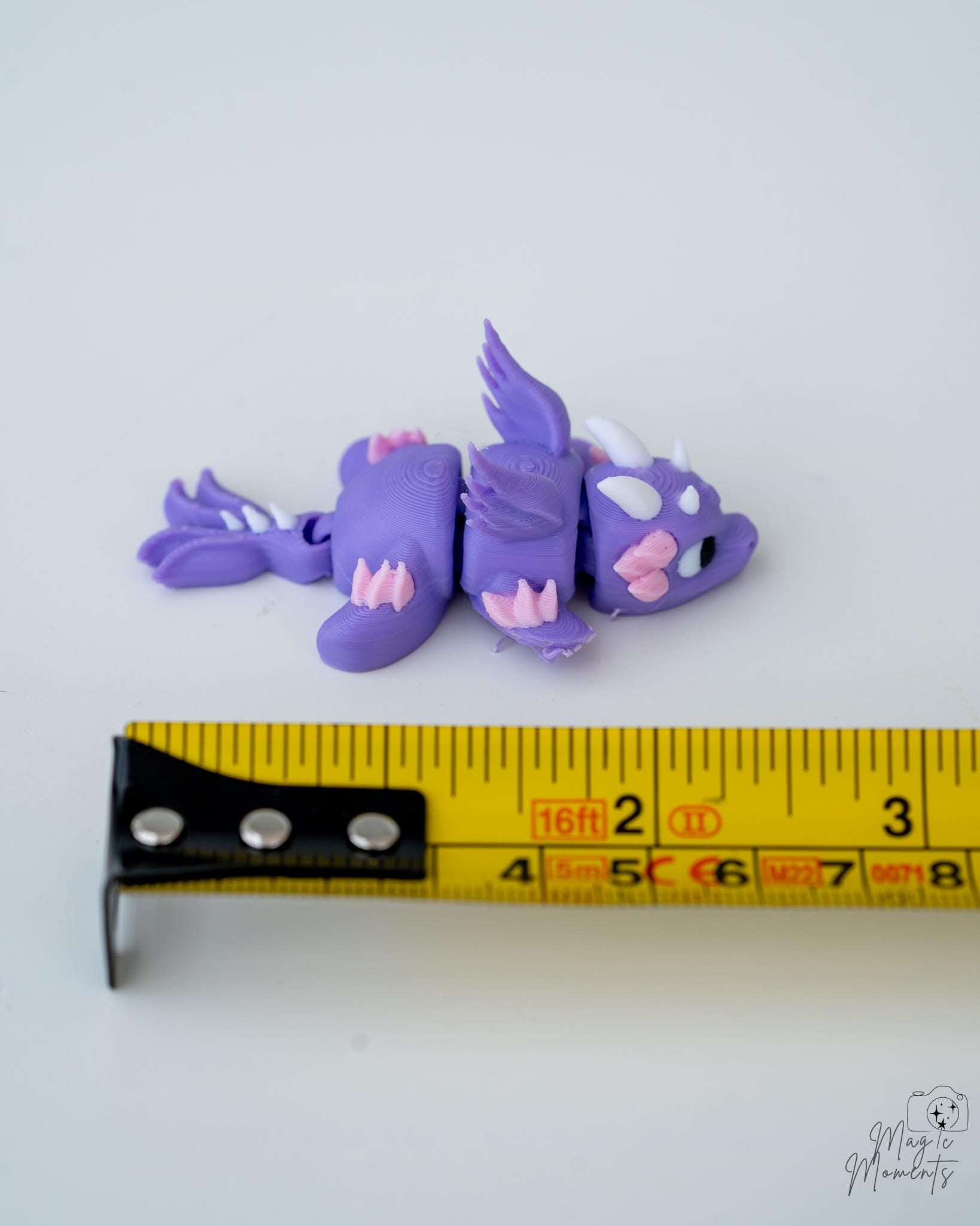 purple triceratops figure next to measuring tape for scale