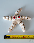 Articulated starfish next to measuring tape for scale