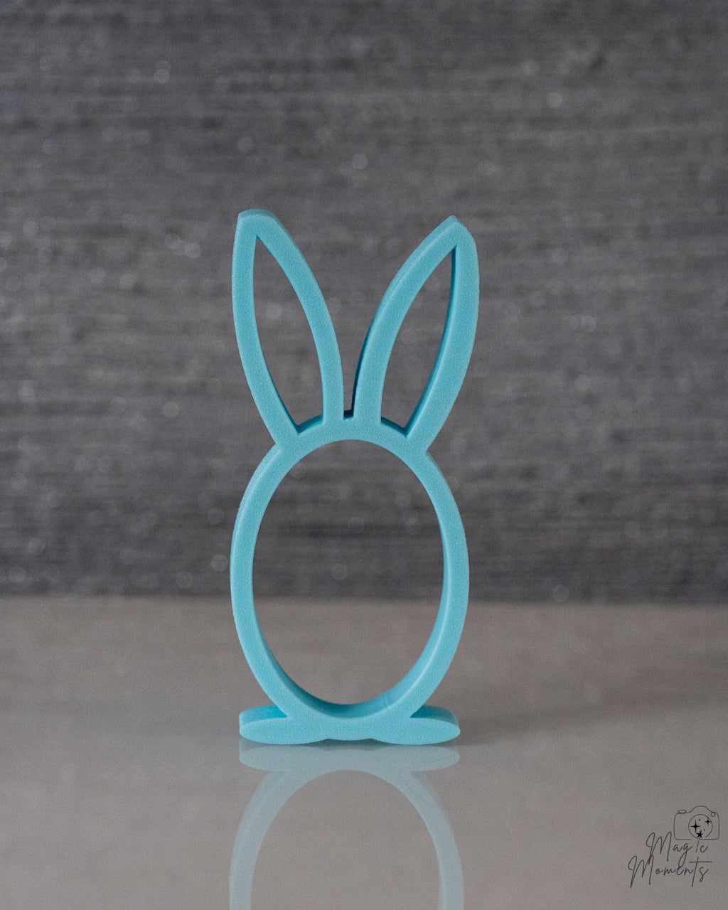 Turquoise bunny-shaped stand on a gray background