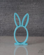 Turquoise bunny-shaped stand on a gray background