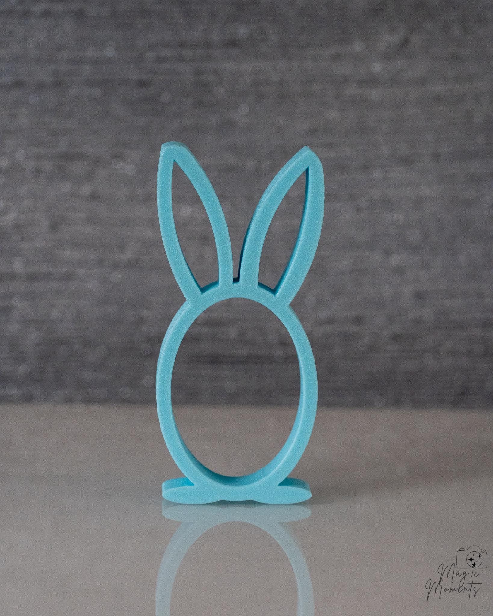 Turquoise bunny-shaped stand on a gray background