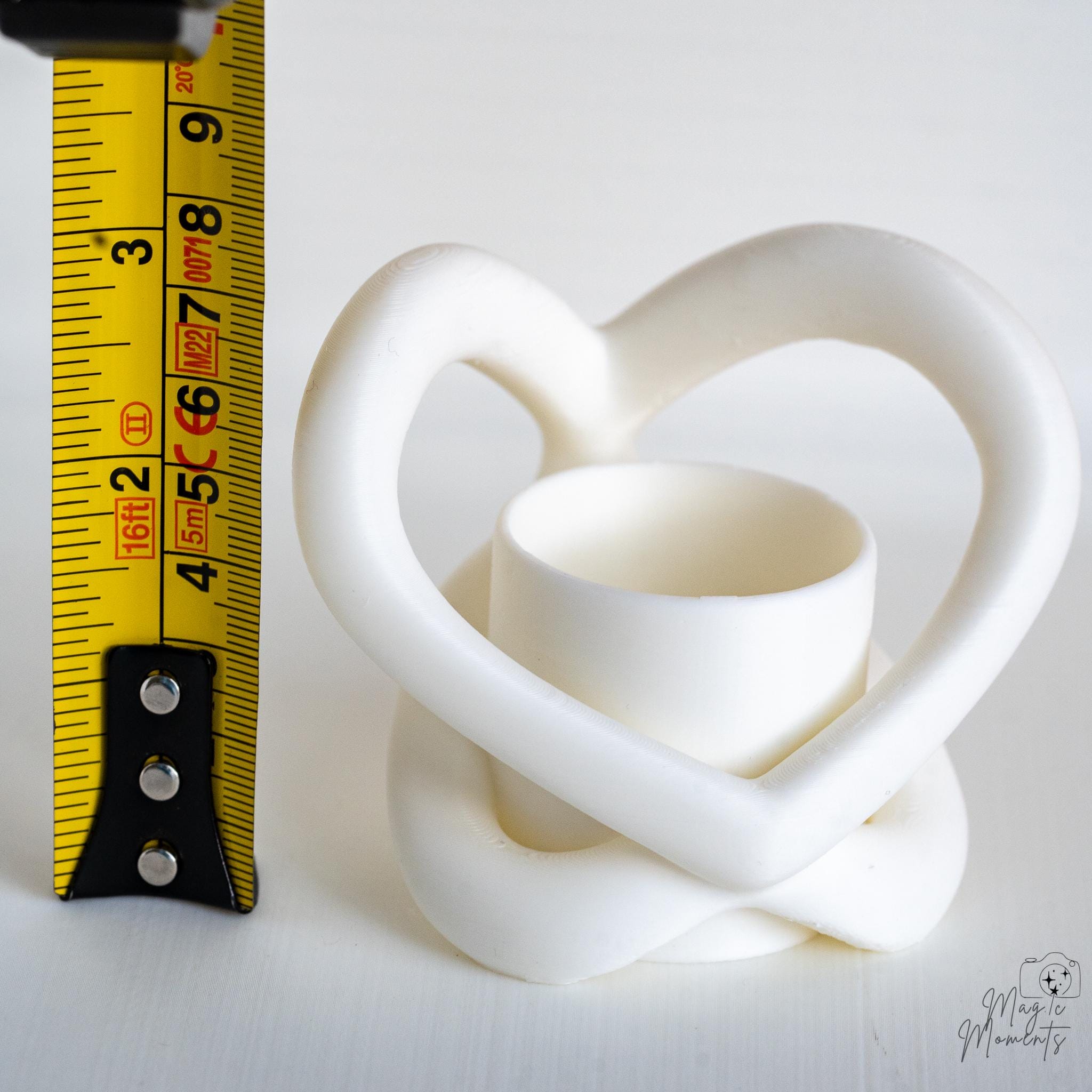 Heart shaped tealight holder next to measuring tape for scale