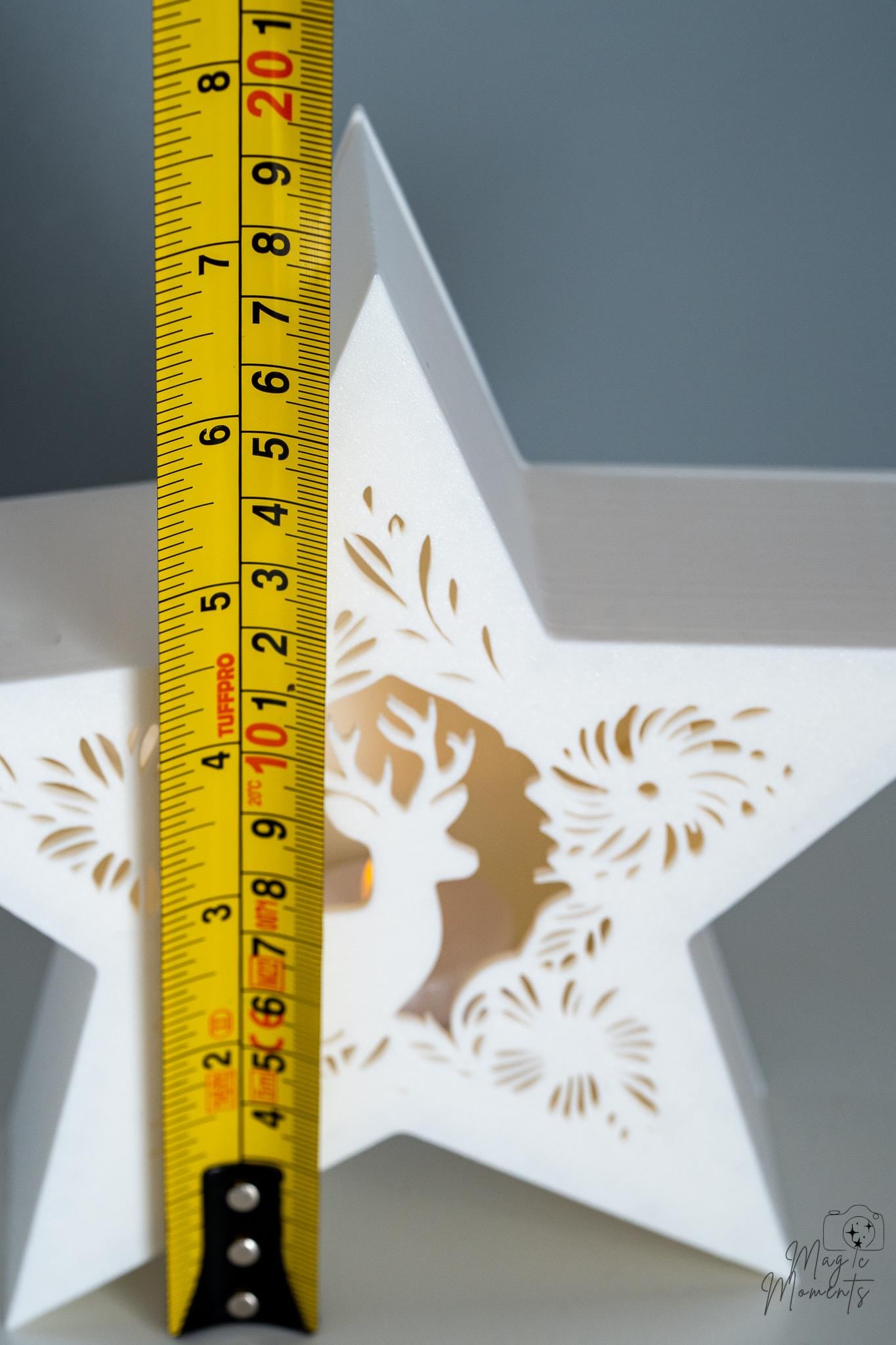 White star-shaped decorative item with cut-out patterns, measured by a yellow ruler 