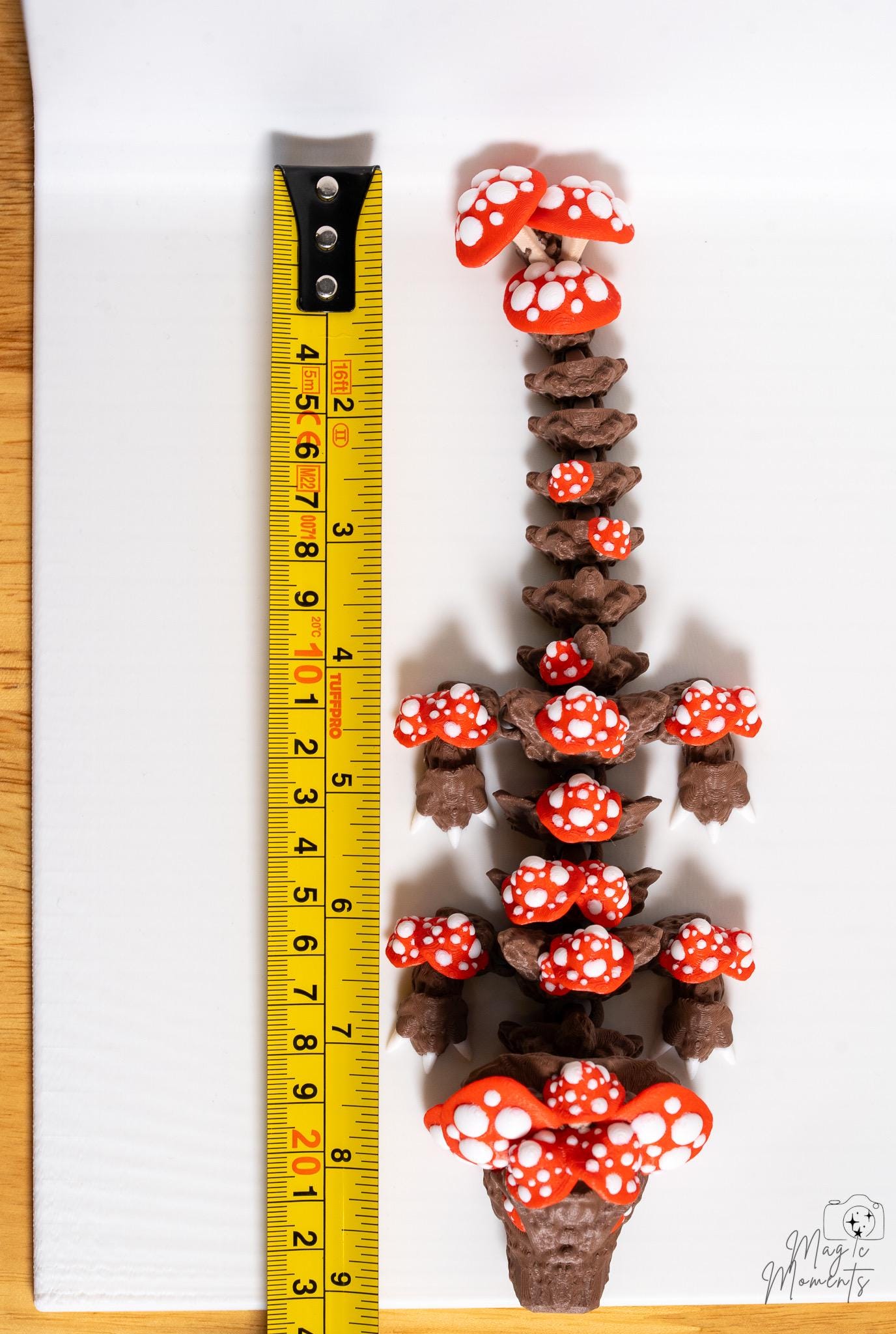 mushroom dragon next to measuring tape for scale