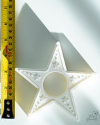 star candle holder next to measuring tape