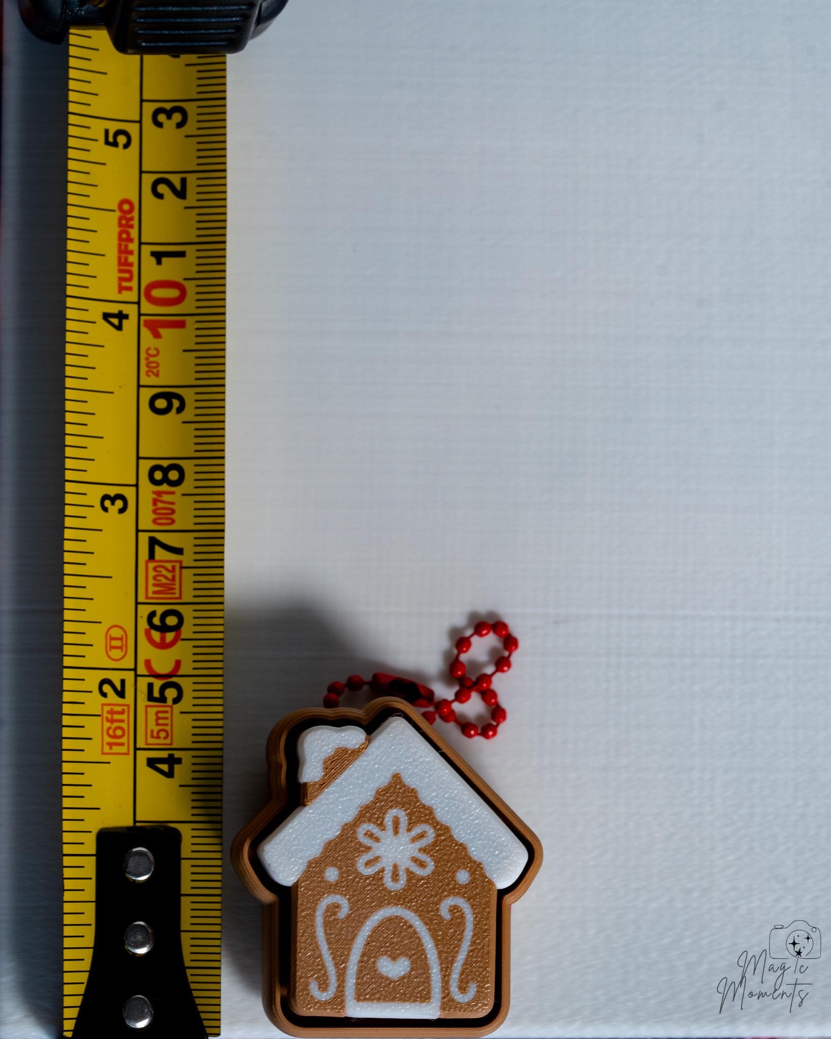 gingerbread house clicker next to measuring tape for scale