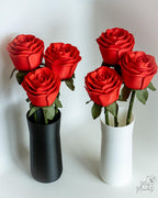 Red rose bouquet displayed in black and white vase