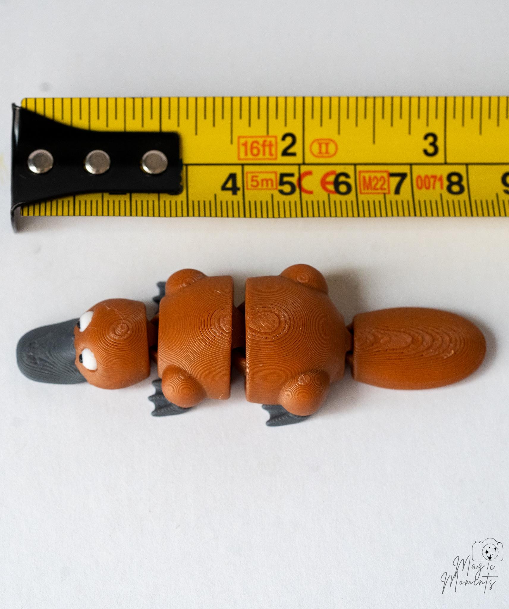 platypus figurine next to measuring tape for scale