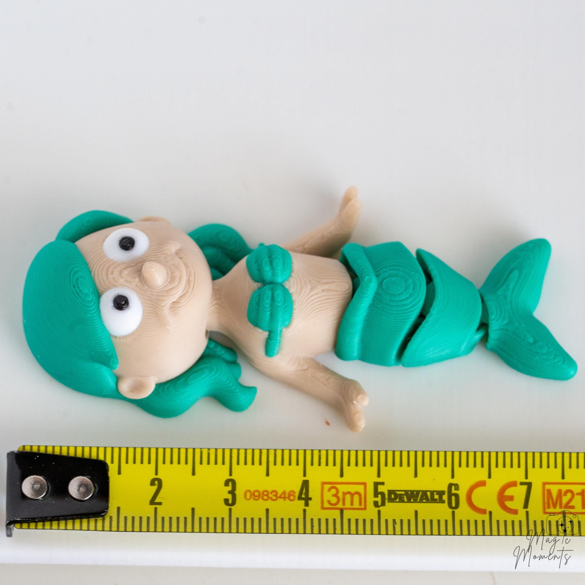 mermaid figurine next to measuring tape for scale
