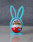 Kinder Surprise egg in a blue bunny holder on a gray background