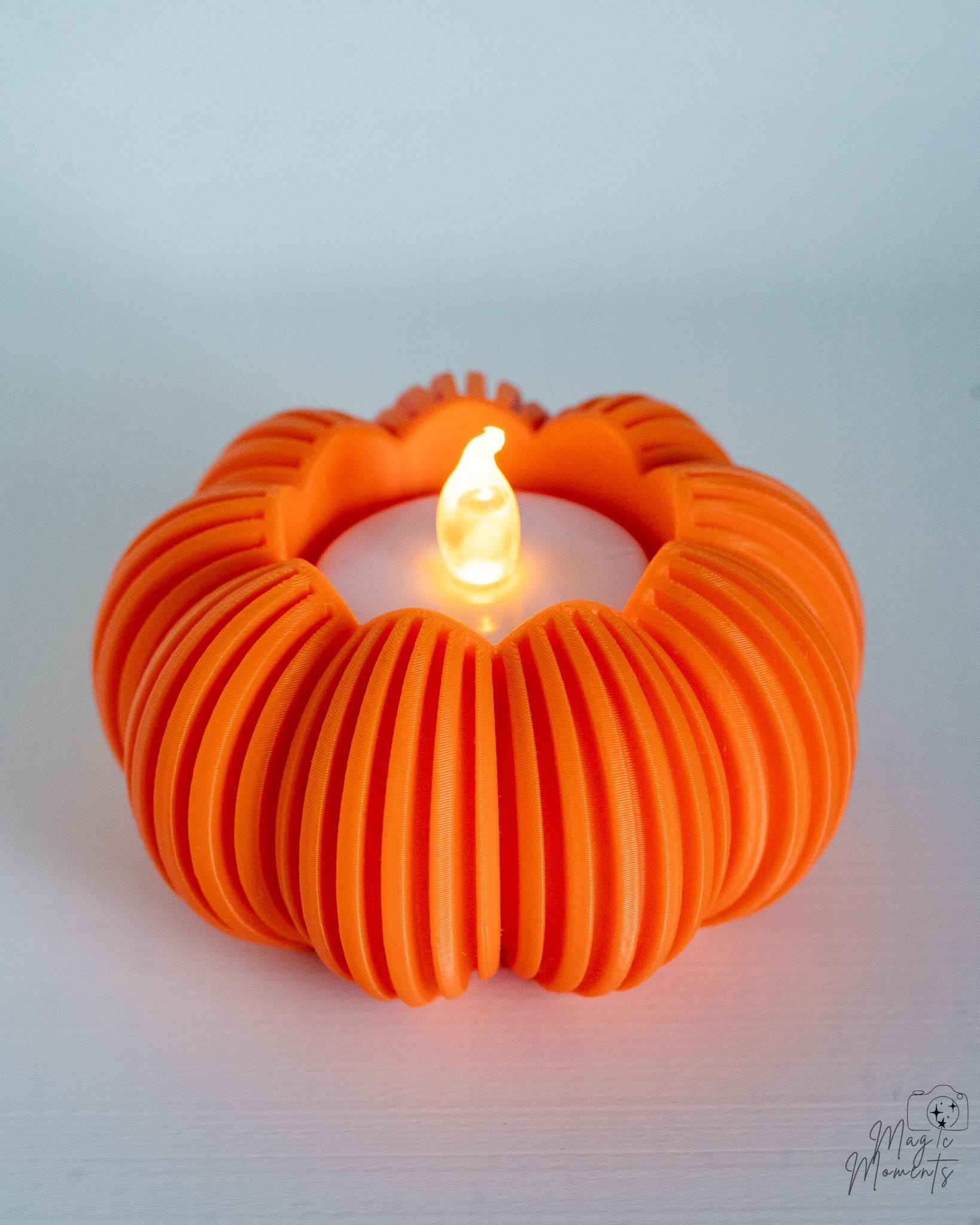 Orange pumpkin tealight holder glowing with LED candle