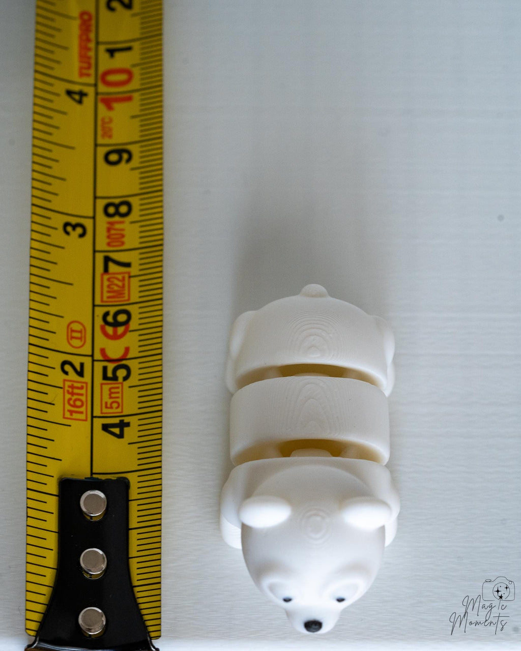 Polar bear figure next to measuring tape for scale