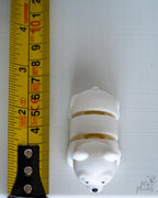 Polar bear figure next to measuring tape for scale