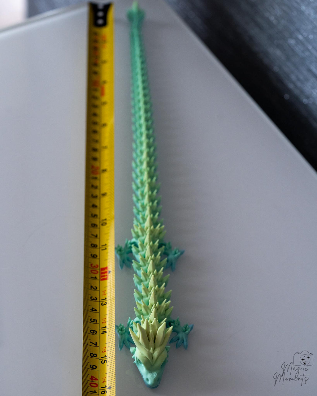 articulated dragon next to measuring tape for scale