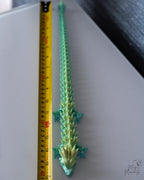 articulated dragon next to measuring tape for scale