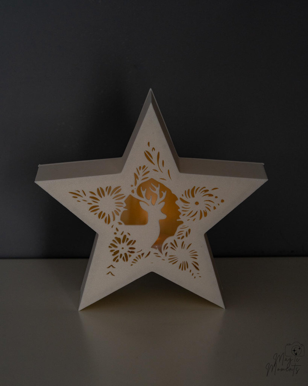 Star-shaped tealight holder with cut-out designs on a dark background