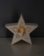 Star-shaped tealight holder with cut-out designs on a dark background