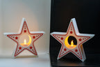 Star-shaped candle holders with red star patterns on a white and black background.