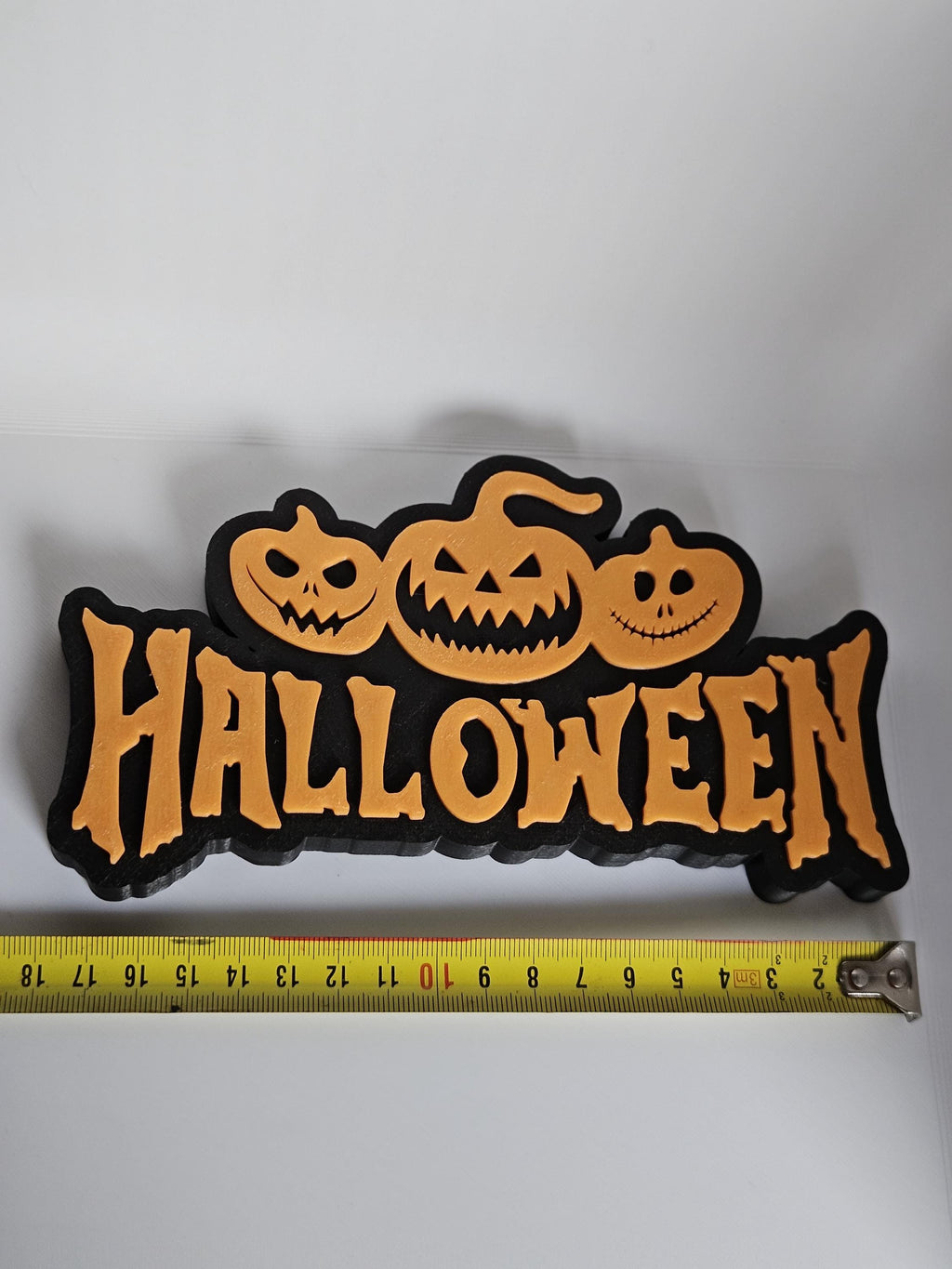 Halloween shelf decoration next to measuring tape for scale