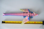 Winged dragon figure next to measuring tape for scale