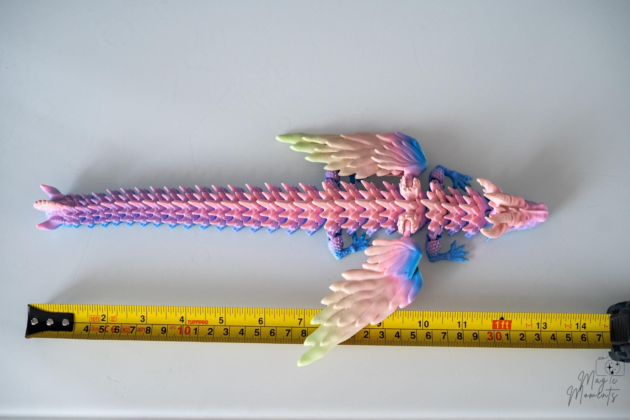 Winged dragon figure next to measuring tape for scale