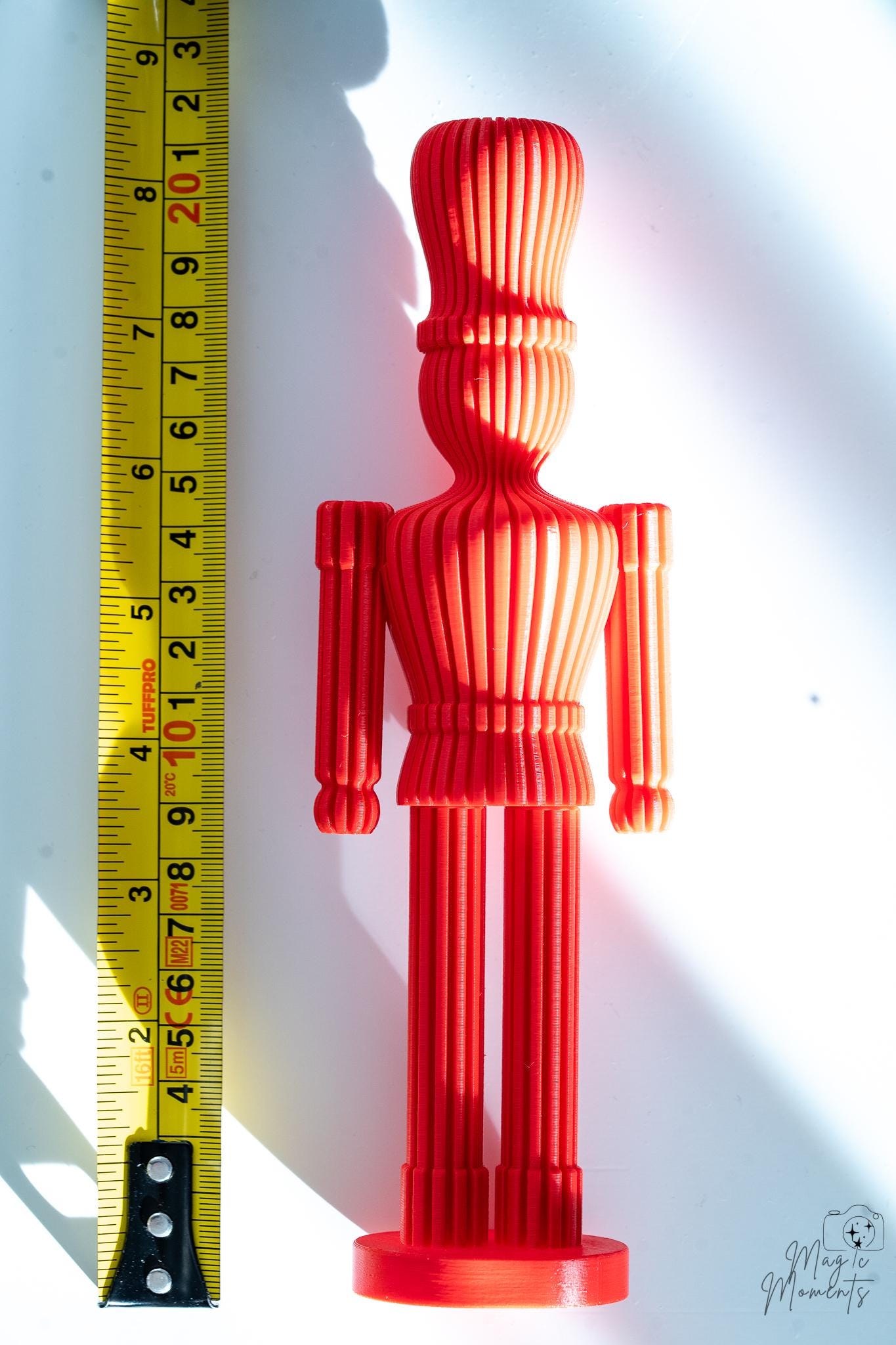 Red nutcracker decoration next to measuring tape for scale