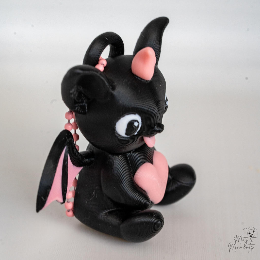 3D printed bat figure with pink wings and heart detail