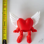 Winged heart shelf sitter next to measuring tape for scale