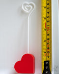 Heart photo holder next to measuring tape for scale
