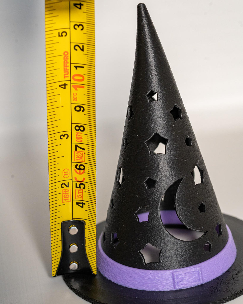 Witch hat tealight holder next to measuring tape for scale