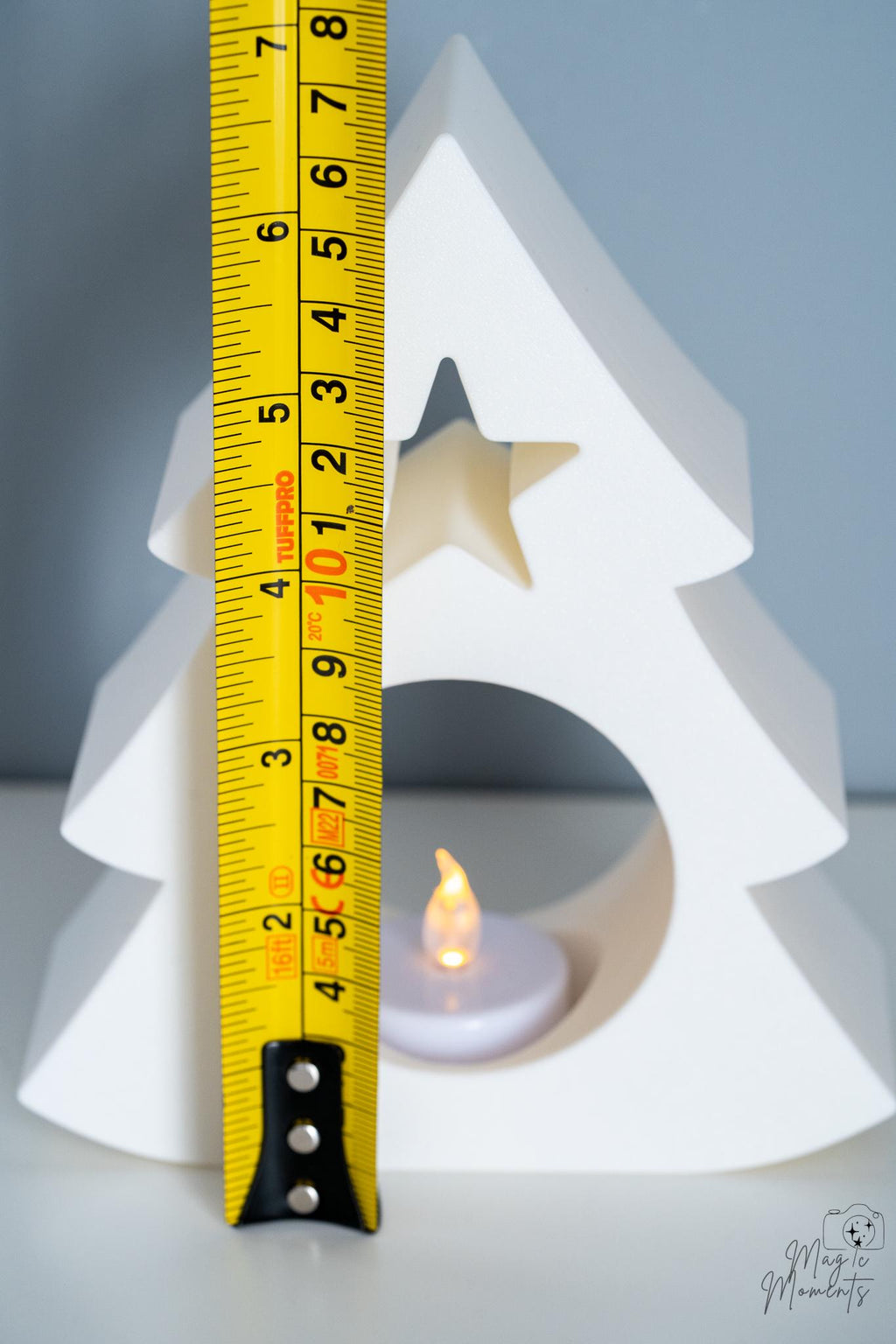 Christmas tree tealight holder next to measuring tape for scale