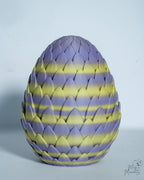 Decorative egg with purple and yellow striped pattern on a light gray background